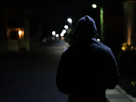 フードを被った怪しい男性の後ろ姿