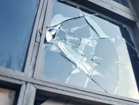 broken glass window reflecting blue sky