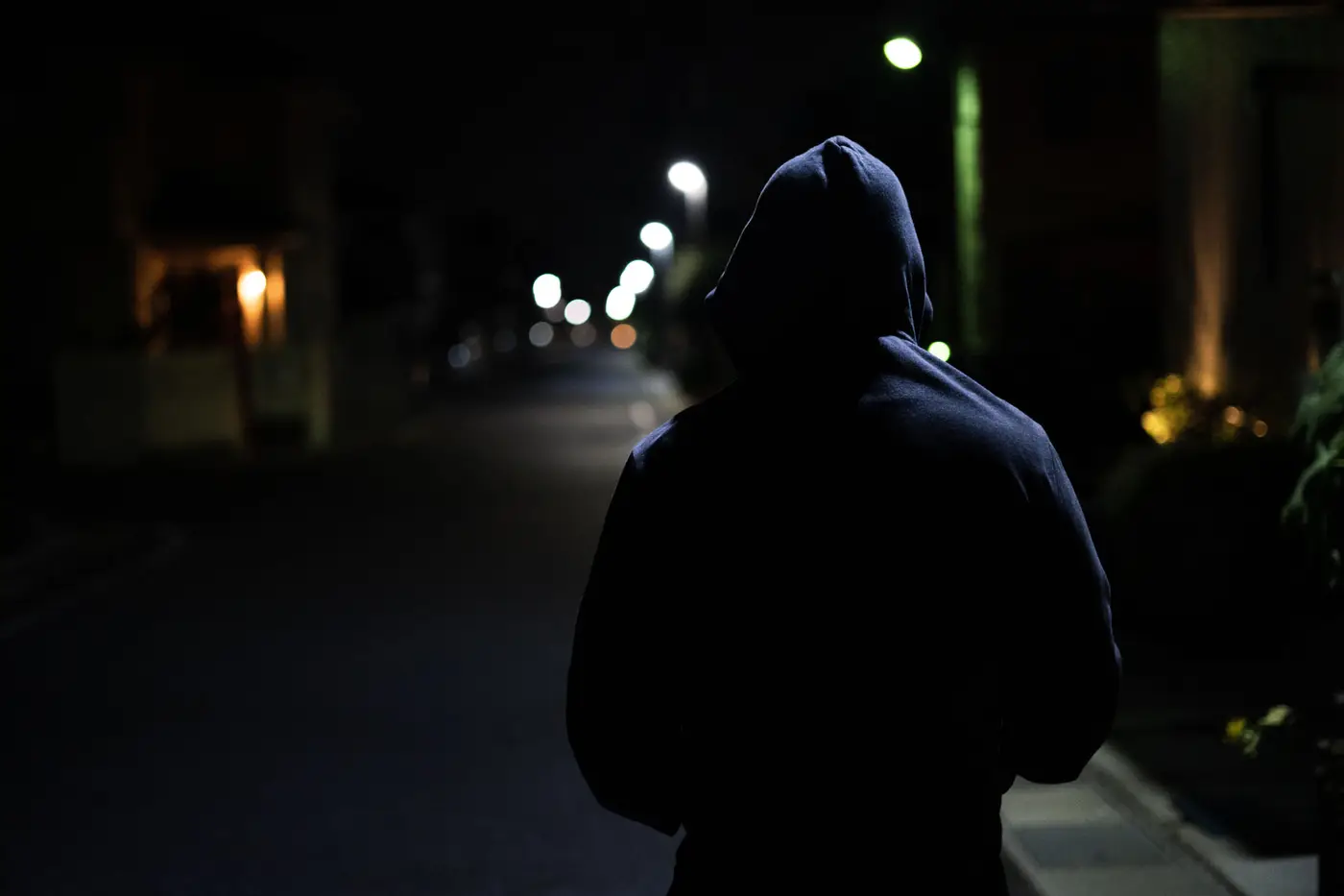 フードを被った怪しい男性の後ろ姿